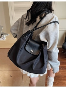 Classic black large capacity nylon tote bag with leather flap shown in office setting
