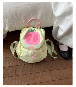 Close-up of a cute mini tomato backpack featuring a pink handle and drawstring closure