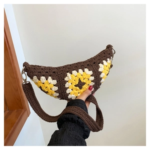 Detail of hand-crocheted crescent bag featuring yellow sunflower pattern and wide strap