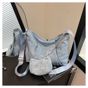 Detail of light blue pleated tote with Happy Sunday embroidery and metal chain strap