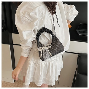 Crossbody tweed bag with lace pearl bow detail and leather pleat handle shown on model