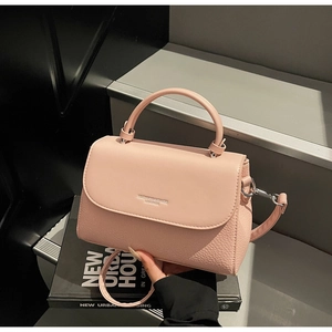 Close-up of pink leather handbag with lychee grain texture and silver hardware details