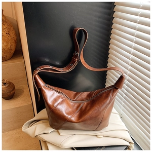 Détail du sac Hobo marron vintage en similicuir huilé brillant avec coutures diagonales