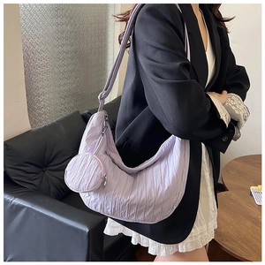 Close-up of lilac crescent shoulder bag with pleated texture and matching coin pouch