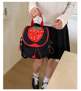 Detail of cute black backpack with red strawberry print and drawstring handles