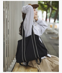 Detail of black canvas tote bag showing wide straps and functional side drawstring closure