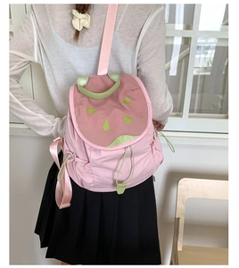 Close-up of pink and green contrast backpack featuring nylon fabric and drawstring closure