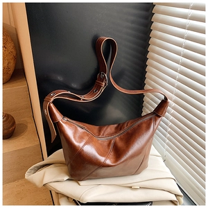 Détail du sac hobo marron vintage avec bandoulière réglable et coutures décoratives