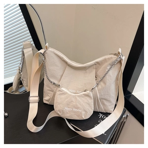 Detail of cream canvas tote bag with Happy Sunday text and small hanging pouch accessory