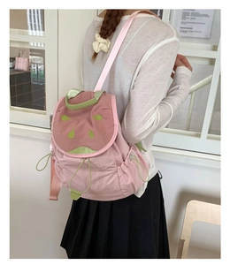 Detail of pink watermelon-style backpack with drawstring closure and green accents