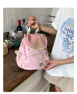 Detailed view of pink watermelon backpack with green drawstring pocket and seed patterns