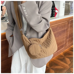 Detailed view of brown pleated crescent crossbody bag with matching round coin purse detail
