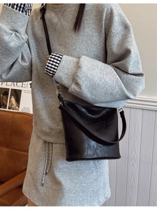 Minimalistische schwarze Beuteltasche mit Lederstruktur und verstellbarem Schultergurt