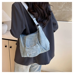 Detail of blue canvas tote bag with Happy Sunday text and matching chain round purse