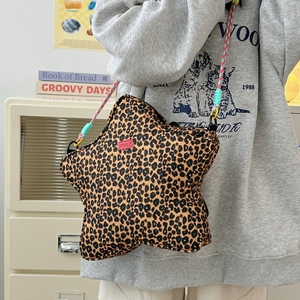 Detail of star-shaped leopard print crossbody bag with colorful woven rope shoulder strap