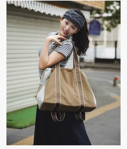 Outdoor shot of a large color-block tote bag with drawstring closure and striped straps