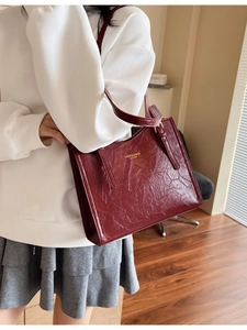 Vintage burgundy tote bag with wrinkled leather texture and long shoulder straps