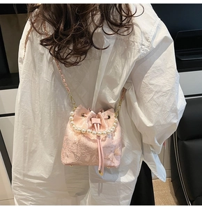 Detailed back view of pink jacquard bucket bag with pearl handle and floral embroidery