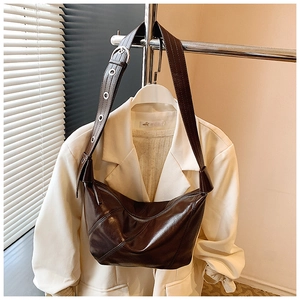 Détail de la bandoulière réglable avec œillets métalliques sur un sac hobo marron foncé