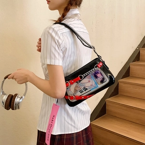 Détail du sac Itabag noir avec fenêtre PVC transparente et lanières de cœur en cuir rouge