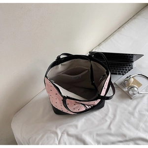 Vista dall'alto di un'ampia borsa tote rosa con fiocchi e tasca interna con cerniera