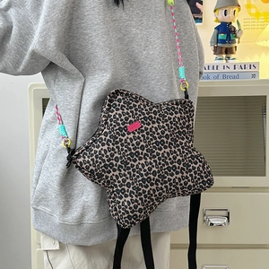Detailed macro view of the star-shaped leopard print bag with colorful woven shoulder strap