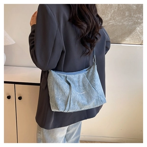 Detail of light blue pleated canvas tote bag featuring white Happy Sunday printed text