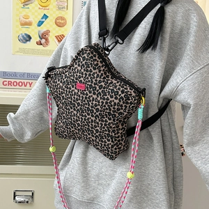 Detail of star-shaped leopard print crossbody bag with colorful woven rope and strap