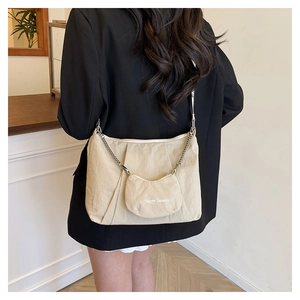 Detail of beige pleated tote bag with Happy Sunday mini coin purse and silver chain