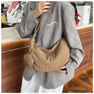 Detail of khaki pleated crescent crossbody bag with small round coin pouch on strap