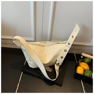 Détail du sac demi-lune blanc cassé avec bandoulière à œillets et fermeture éclair en métal