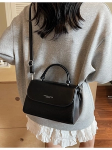 Elegant black lychee grain leather shoulder bag with top handle and adjustable strap