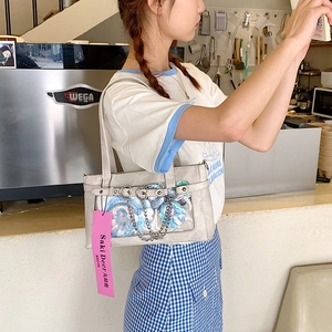 Detail der hellgrauen Ita Bag mit Sichtfenster für Anime-Pins und dekorativer Metallkette