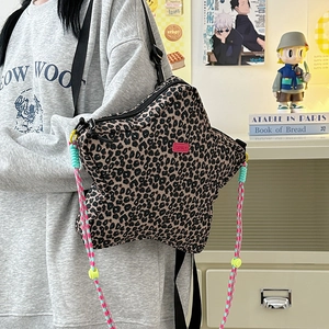 Detail of star-shaped leopard print crossbody bag with colorful woven rope and brand logo