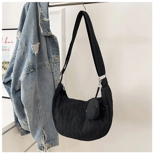 Detail of black pleated hobo bag with adjustable strap and small round coin purse
