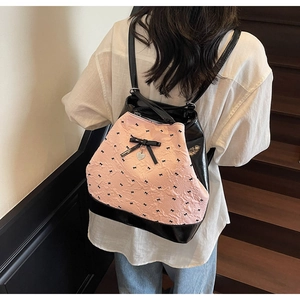 Dettaglio della trama arricciata rosa e del fiocco nero sullo zaino da donna