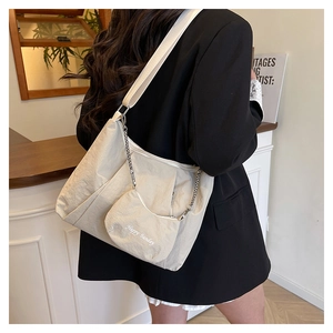 Detail of off-white pleated tote bag with Happy Sunday coin purse and metal chain link