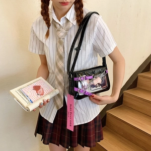 Détail du sac ita en cuir verni noir avec boucles cœur violettes et chaînes argentées