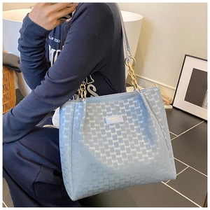 Vue détaillée du sac cabas bleu clair avec texture monogramme et chaîne en métal