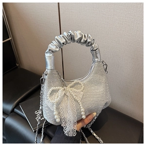 Detail of silver sequin hobo bag featuring lace bow and pearl chain decoration