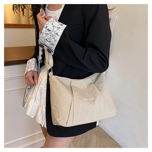 Detail of beige canvas crossbody bag with Happy Sunday print and pleated design