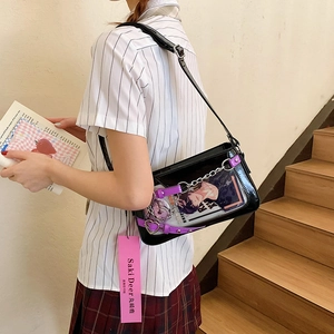 Détail du sac bandoulière en cuir verni noir avec insert anime et boucle cœur