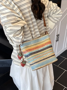 Colorful striped woven straw bucket bag with strawberry charms and leather strap
