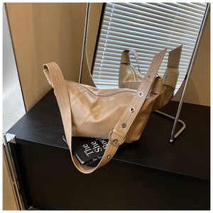 Détail du sac hobo beige montrant le patchwork en cuir diagonal et la boucle ronde en argent