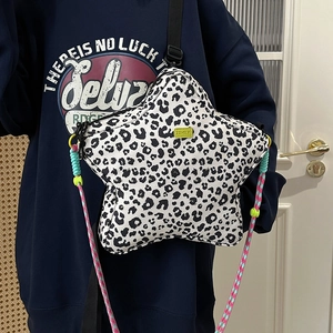 Detail of star-shaped leopard print crossbody bag with neon green logo and woven strap