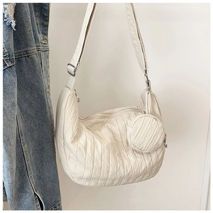 Detail of off-white pleated dumpling bag with adjustable strap and small round coin purse