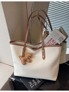 Minimalist beige crocodile embossed tote bag with brown handles and a bear charm