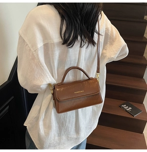 Close-up of vintage brown glossy leather handbag with Fashion & Bags gold lettering