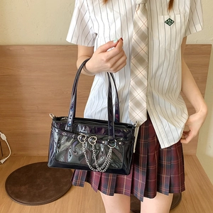 Glänzende schwarze PU-Leder Ita-Bag mit Herzanhängern und Kettendetail in Lifestyle-Ansicht