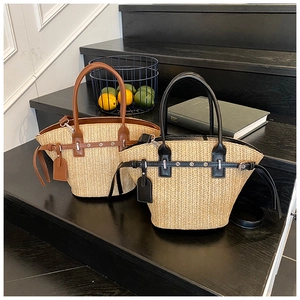 Detail of woven straw tote bags with leather trim and handles in brown and black